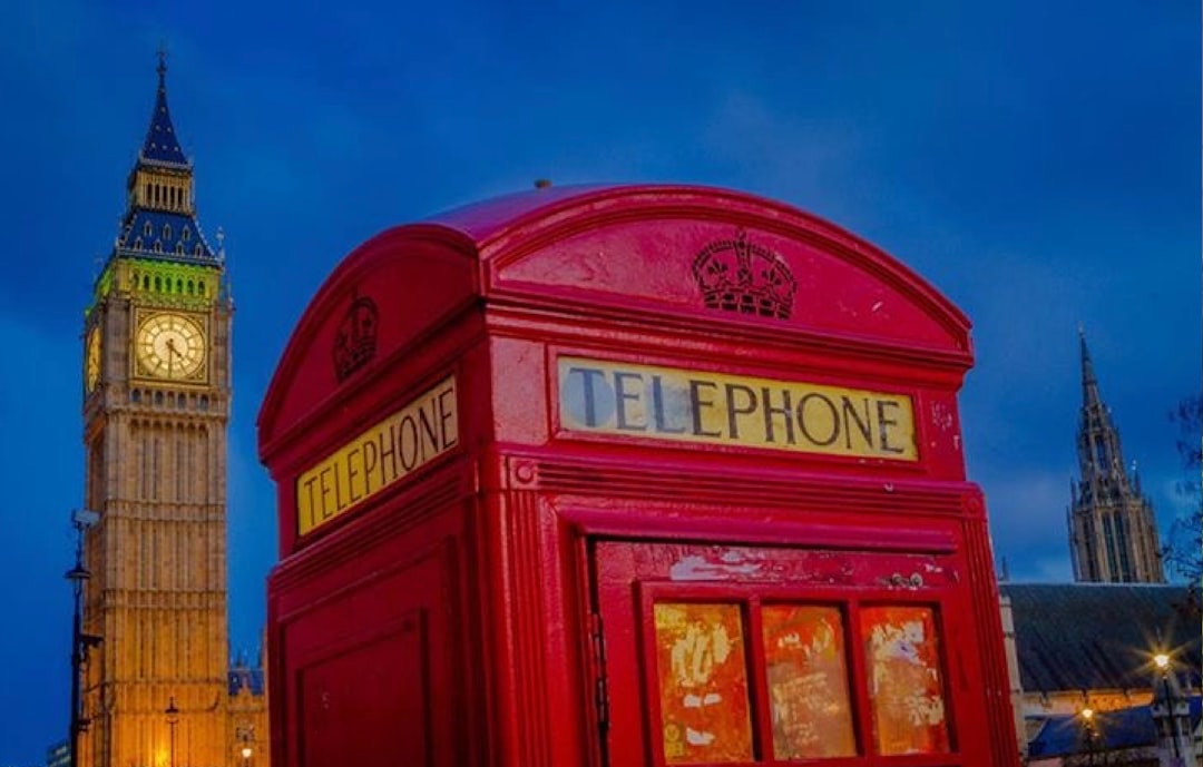 UK small business owner reviewing AI phone answering dashboard on laptop with call in progress