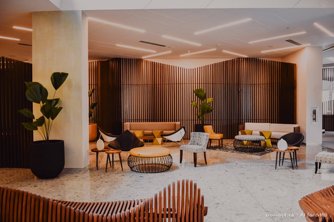 Gestor de hotel português a rever painel de reservas e fluxo WhatsApp em portátil no lobby de hotel em Lisboa