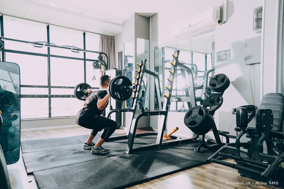 A US boutique gym floor with weight racks and members training in the background