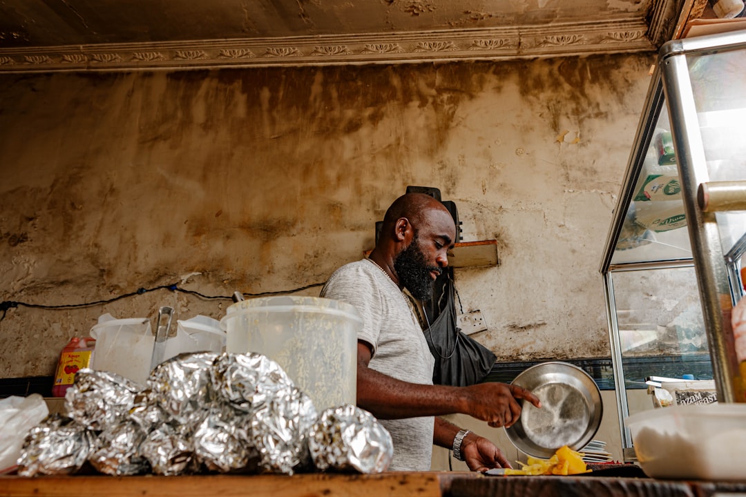 Tanzanian shopkeeper reviewing WhatsApp orders on smartphone