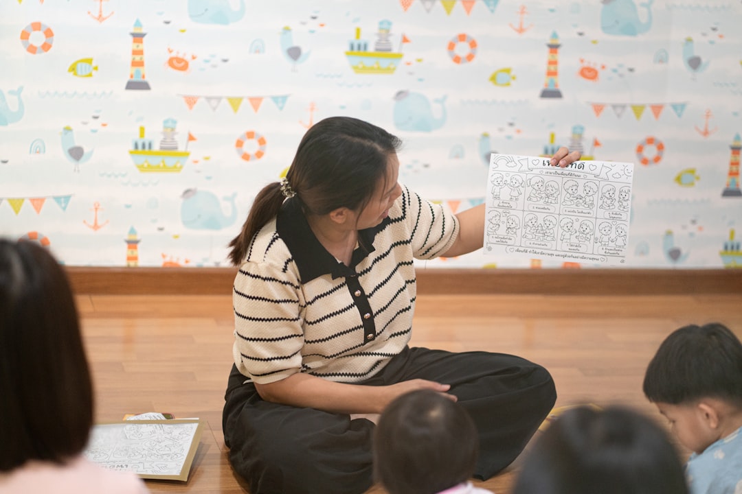 A woman holding a worksheet for children in a room with nautical wallpaper
