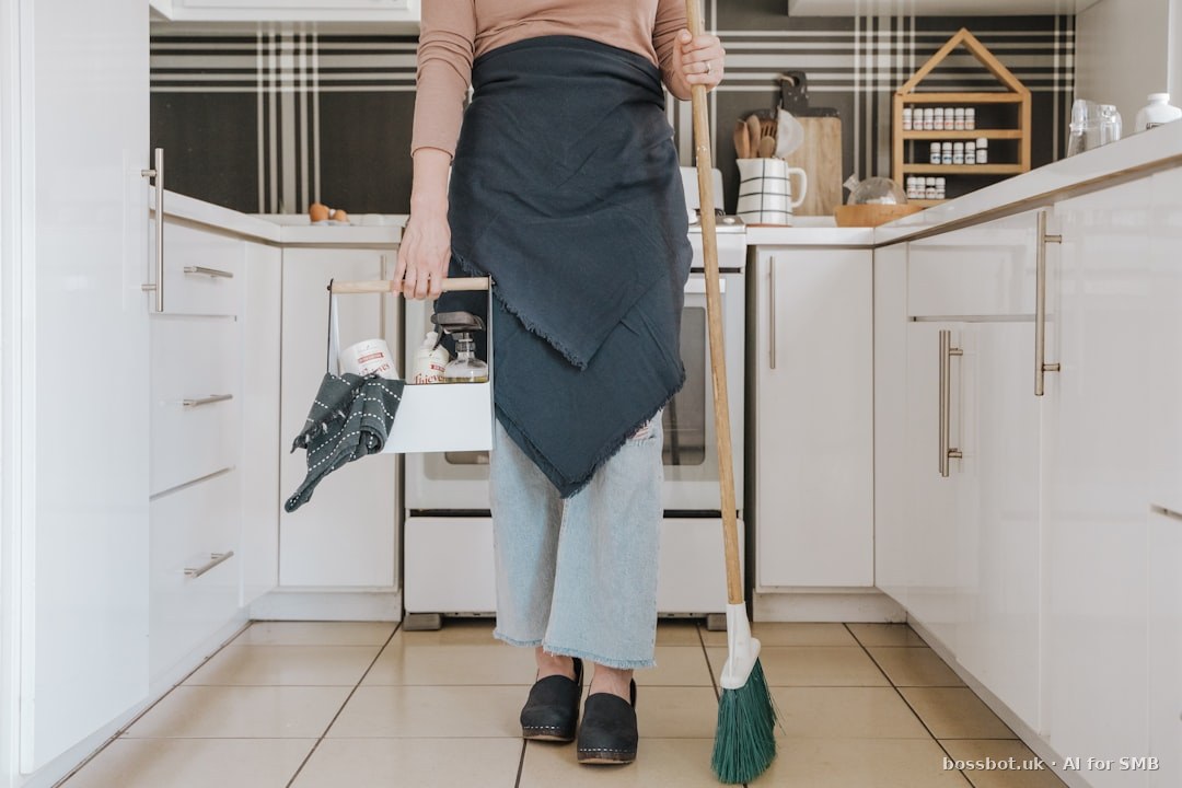 A woman standing in a kitchen holding a broom