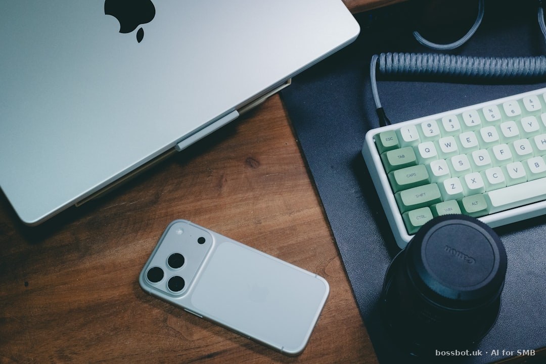 Silver smartphone and laptop on wooden desk in UAE business setting