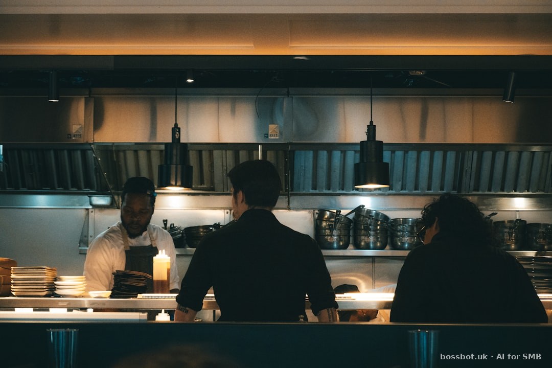 Chefs prepare food in a dimly lit restaurant.