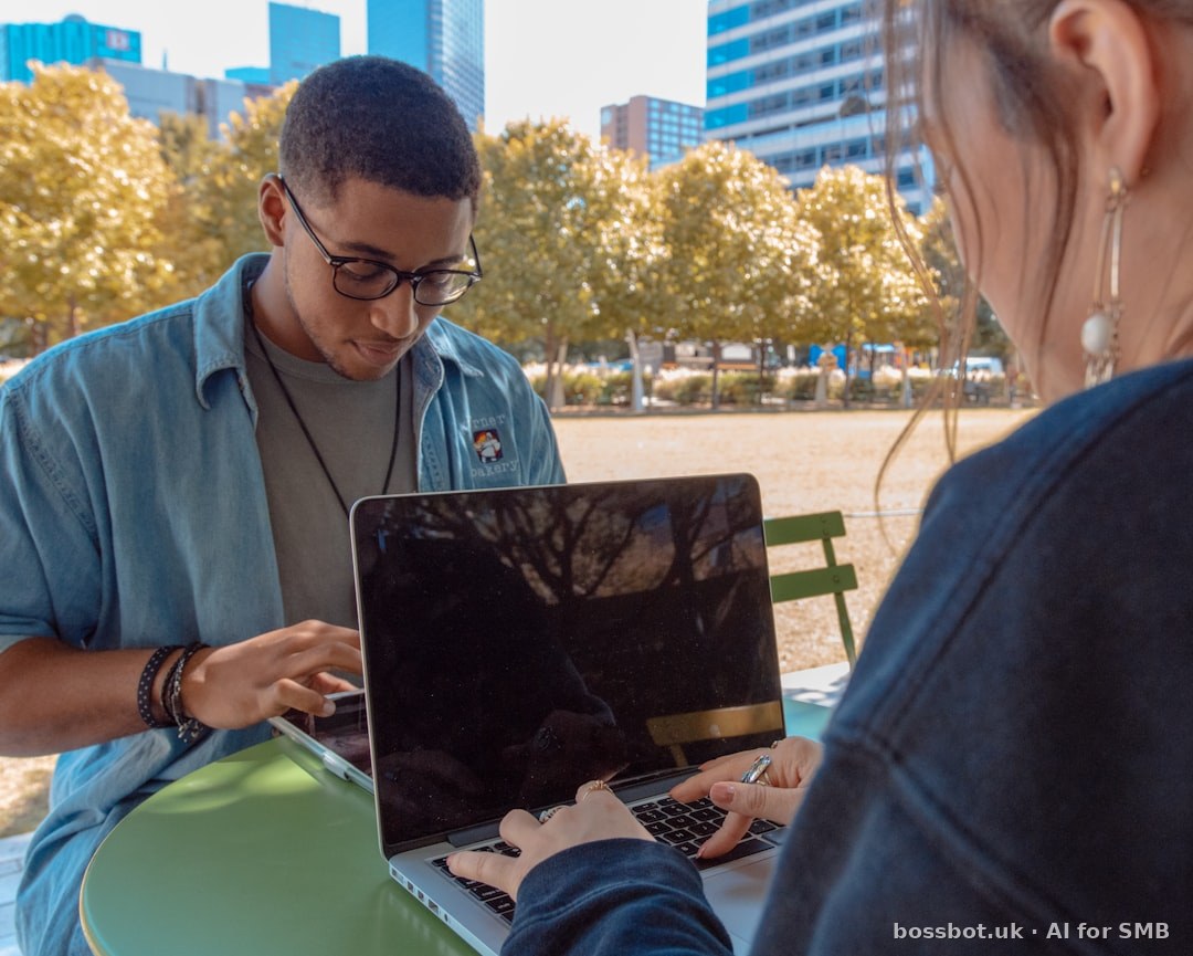 Man and woman sitting while using macbook pro